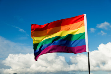 Rainbow flag waving on sky