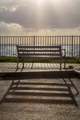 An empty bench against the backdrop of the sea at sunset. Israel. Bat Yam