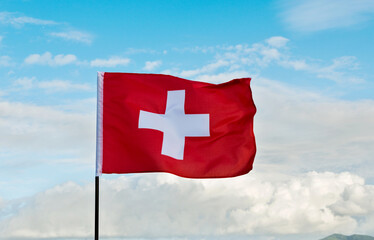 Swiss flag waving against sky