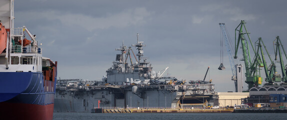 MARITIME TRANSPORT - Freighter and  American amphibious assault ship at the wharfs - obrazy, fototapety, plakaty