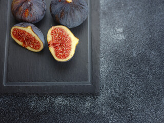 fresh ripe figs fruit and olive branch on dark table. mediterranean food concept