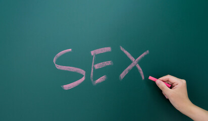 Hand writting SEX on blackboard