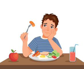 Young man has no appetite to eat food sitting in front of breakfast at table 
