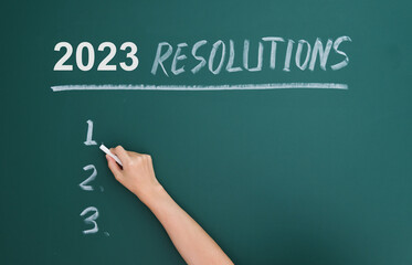 Handwriting 2023 resolutions on blackboard