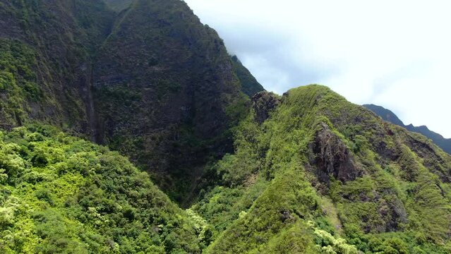 Clouds cast large shadows over the canopy of the verdant Koolau mountain forest