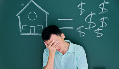 Man in front of drawing house and money on blackboard