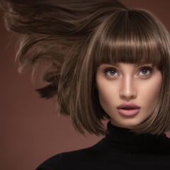 Portrait of a beautiful brown-haired woman with a short haircut on a brown background