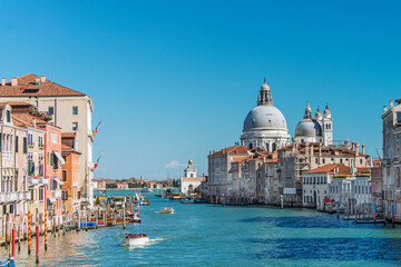 Fototapeta na wymiar Gondolas and boats sailing down the Grand Canal in Venice. Italy, 2019