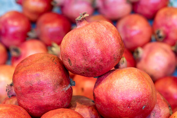 Pomegranate on the market counter. Pile of ripe pomegranates