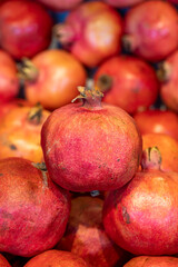 Pomegranate on the market counter. Pile of ripe pomegranates