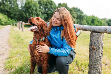 Woman and her friend dog on country road background. Human and a dog. Concept of solitude and...