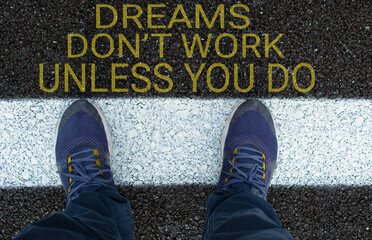 Top View of sneakers on the road with the text: Dreams Don't Work Unless You Do