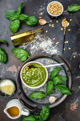 Obraz na płótnie Canvas Homemade pesto sauce and ingredients, Traditional Italian pesto recipe for pasta on a dark background, vertical image. top view. place for text