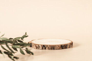 Natural round wooden stand for presentation and exhibitions on pastel beige background. Mock up 3d...
