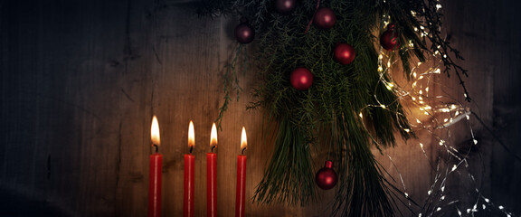 Horizontal christmas and advent background with four red burning candles and natural decoration on...