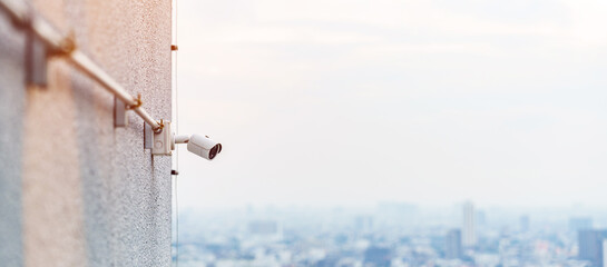 Modern CCTV camera against city and sky background. surveillance, video record and monitoring concept