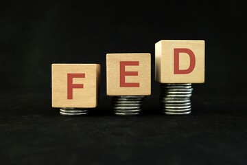FED or Federal Reserve System increase in interest rate or hike concept. Wooden blocks in dark black background.