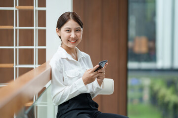 Attractive young Asian woman using mobile phone in the cafe.