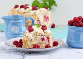 Baked meringue roll with cream and fresh red raspberry, white background.