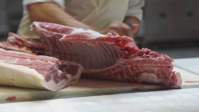In the meat shop, the butcher separates the meat from the carcass of the animal