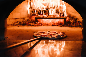 The chef puts the Margherita, four cheese or meat pizza on a shovel in the oven. A firewood oven...