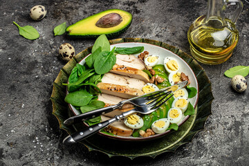 salad avocado, grilled chicken fillet, quail egg, spinach, walnut on a dark background. keto diet. Healthy fats, clean eating for weight loss, Long banner format. top view