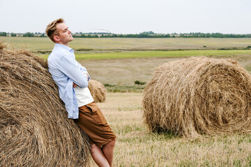Naklejka na ściany i meble Boy Jumps From a Hay Stack in a Sunny Field