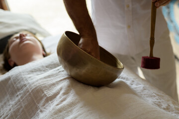 Male hands with Nepal Buddha singing bowl, close up, during healing sound therapy, alternative...