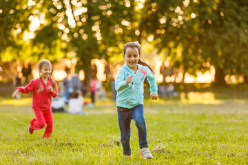 Adorable little girls having fun playing outdoors on summer day © Angelov