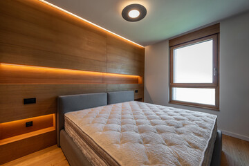 Modern bedroom interior with wooden walls and warm ambient light