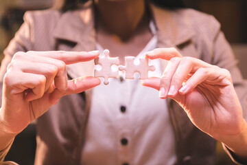Close-up of business hands connecting jigsaw puzzle, business problem solving, success and goal achievement, the last jigsaw is the link of all the pieces.