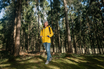Fototapeta premium Woman backpacker walking through woodland.