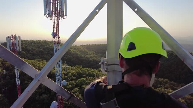 Technician fixing the antennae, at top of telecom tower. Concept of dangerous and risky job.