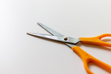 白いテーブルの上にステンレス製のハサミ