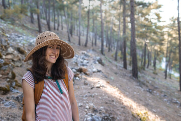 Portrait of a woman with a backpack and a straw hat