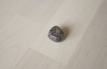 colored natural stone of brown color, labrador on a light background. Astrology, talisman for the zodiac sign Pisces, stone labrador