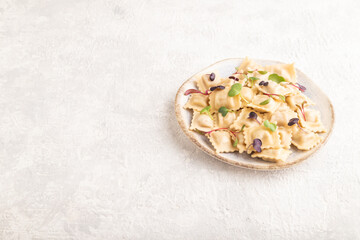 Dumplings with pepper, herbs, microgreen on gray concrete. Side view, copy space.