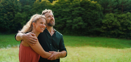 Close up of happy couple looking and dreaming about future, outdoor at meadow.