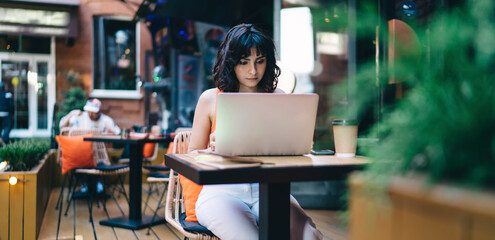 Focused woman working on netbook in cafe