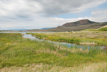 Fototapeta premium Marshy landscape with lake and mountains