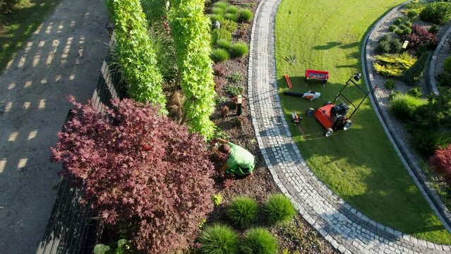 Caucasian Gardener Performing Seasonal Maintenance Inside Large Backyard Garden
