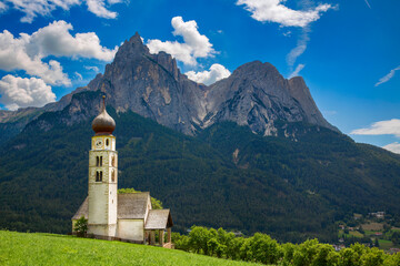 Fototapeta na wymiar St Valentine's Church, Seis am Schlern, Italy, with the Impressive Mountain Schlern in the Background