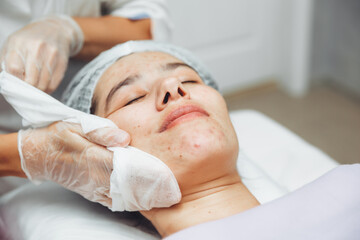 A cosmetologist cleanses the skin of a beauty salon client before the procedure and facial massage. The concept of beauty and health. cosmetology.