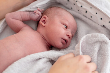 close-up of a baby with a few days of life lying in her crib. concept family and care of the newborn