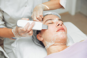 Obraz na płótnie Canvas Ultrasonic cosmetic scrubber. Facial cavitation procedure. Salon skin care procedure. Professional hardware peeling. Acne removal. contaminated person