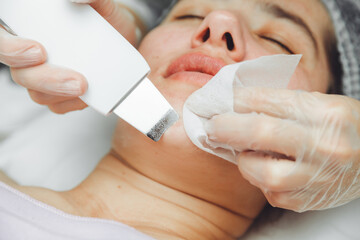 Ultrasonic cosmetic scrubber. Facial cavitation procedure. Salon skin care procedure. Professional hardware peeling. Acne removal. contaminated person