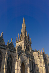 Fototapeta premium A view of the Notre-Dame church with blue summer sky in the centre of Carentan, Normandy, France
