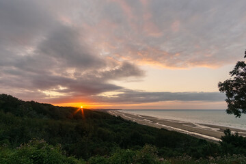 View over Omaha beach on the french atlantic coast during sunset with red sunlight touching the clouds, Colleville-sur-Mer, Normandy, France - obrazy, fototapety, plakaty