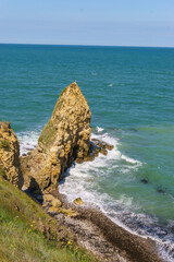 Cliffs at the northern french coast with the sea on a sunny summer day at Pointe du Hoc,...