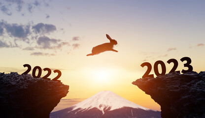 2022から2023へジャンプするウサギ　2023年年賀状素材 - obrazy, fototapety, plakaty